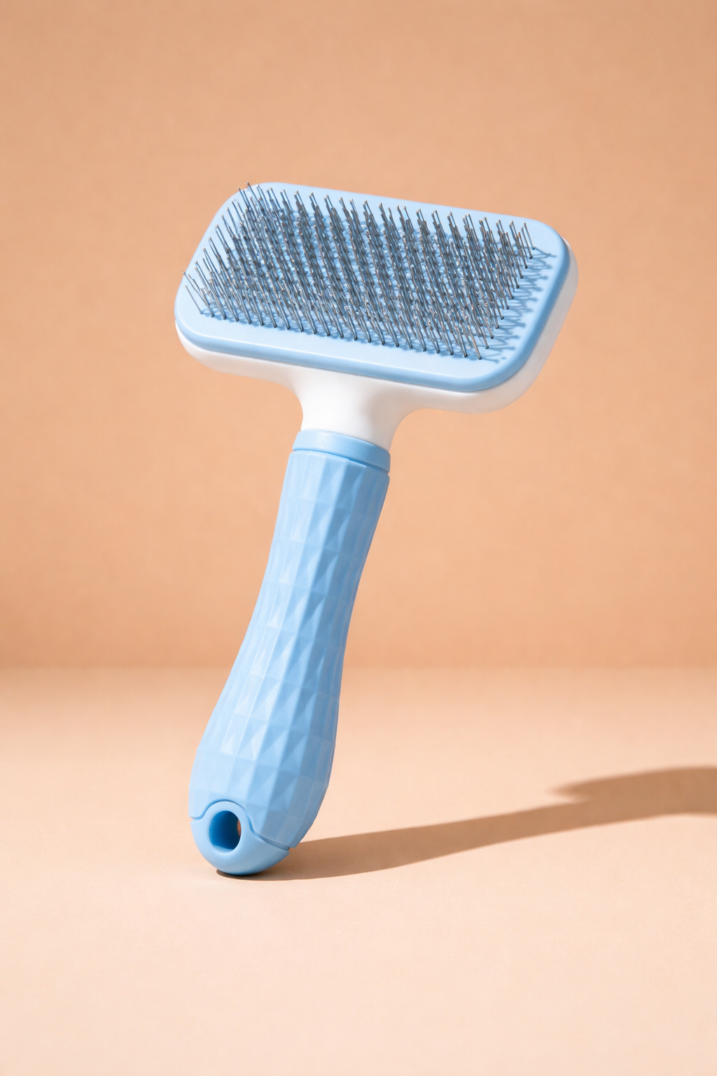 Pet slicker brush on beige backdrop